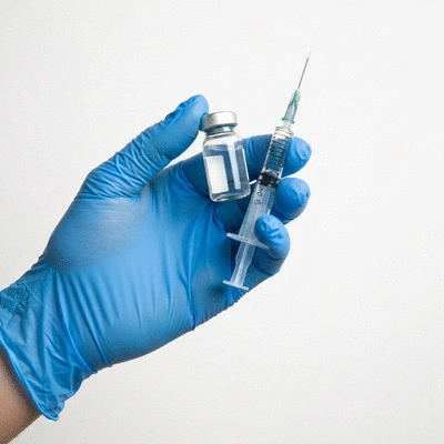 Close up of a veterinarian hand holding a small vaccine vial and syringe